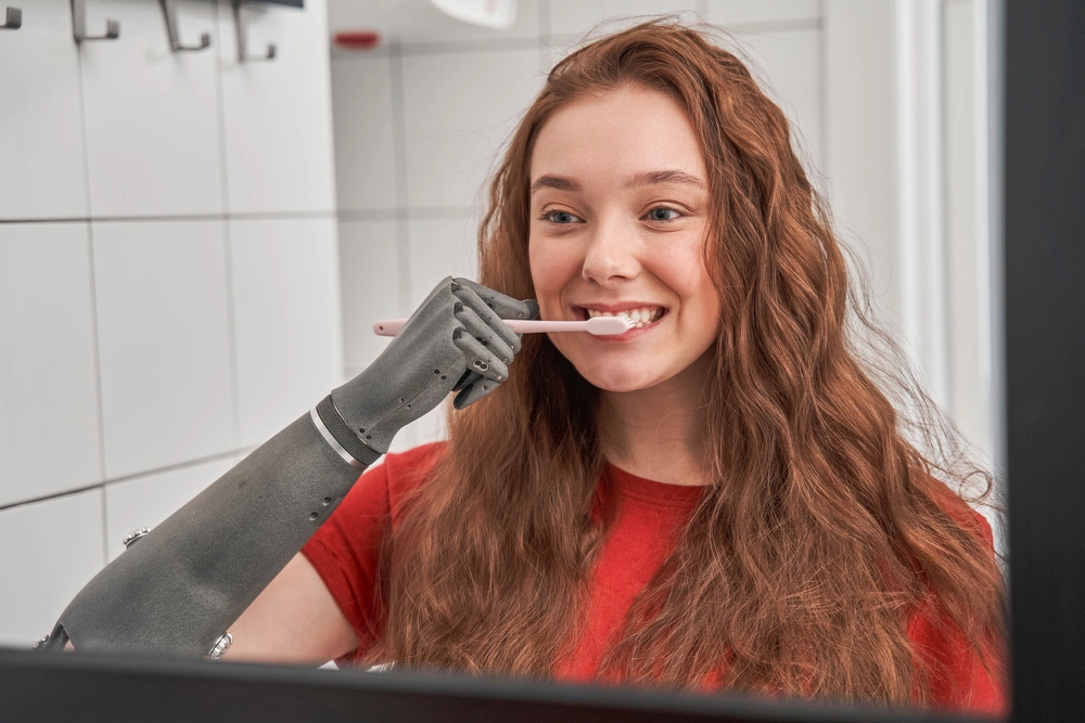 women with prosthetic arm brushing her teeth