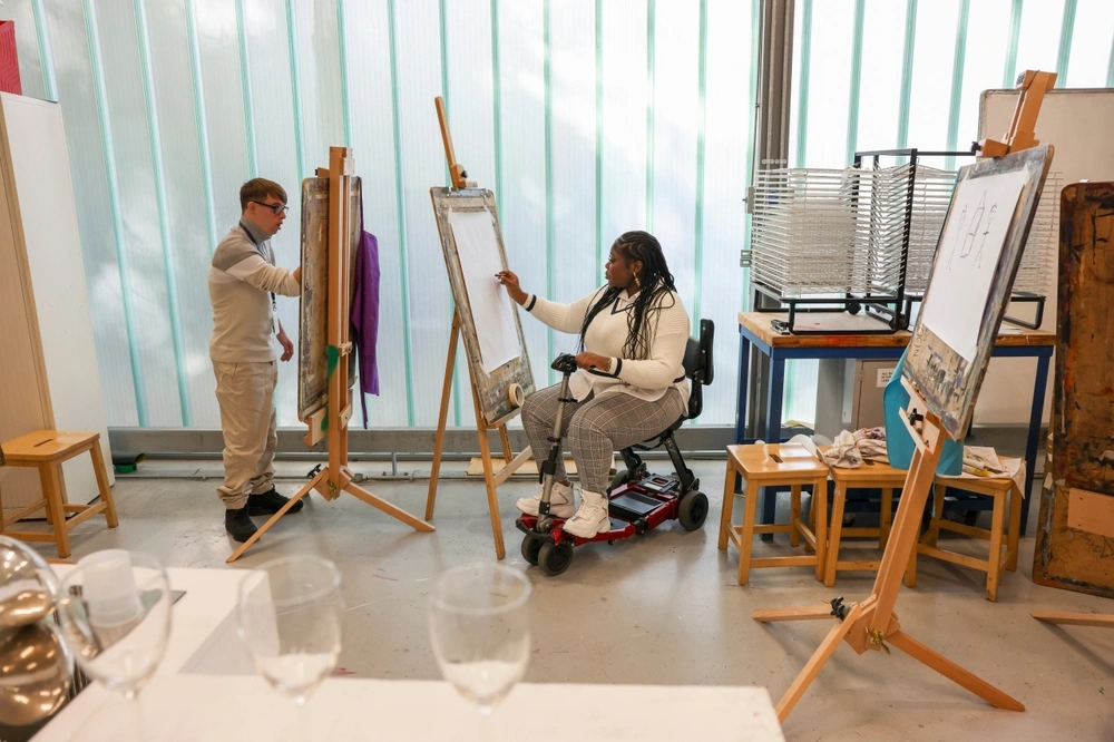 disabled women on wheel chair and a down syndrome boy painting